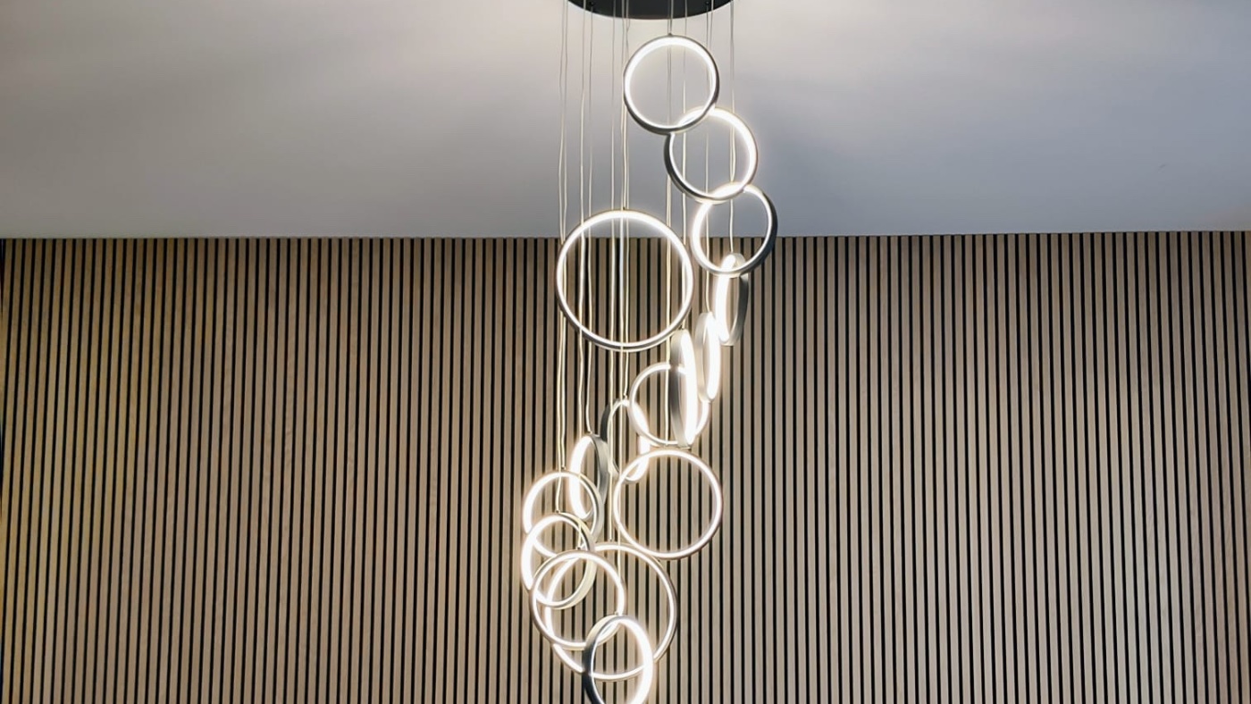 Vertical oak slat accent wall with ring chandelier